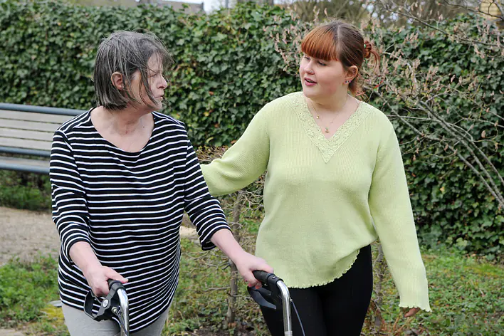 Auszubildende mit Bewohnerin im Garten der Einrichtung