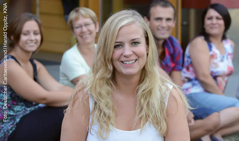 Sozialarbeiterin im Vordergrund, Team im Hintergrund