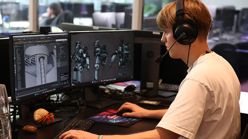 Ein PIXL VISN Student arbeitet an seinem 3D Projekt an zwei Bildschirmen