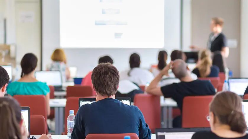 Klassische Vorlesungssituation an der Hochschule: Studierende im Auditorium während eines Fachvortrags in einem modernen, lichtdurchfluteten Hörsaal