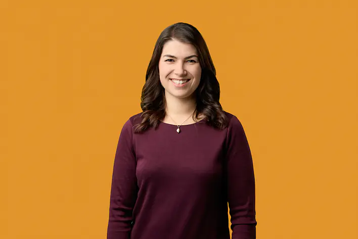 Studentin vor orangefarbenem Hintergrund