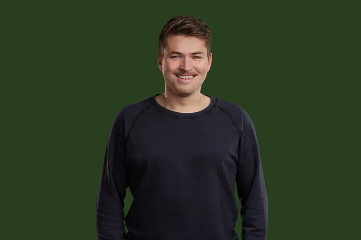 Student vor dunkelgrünem Hintergrund