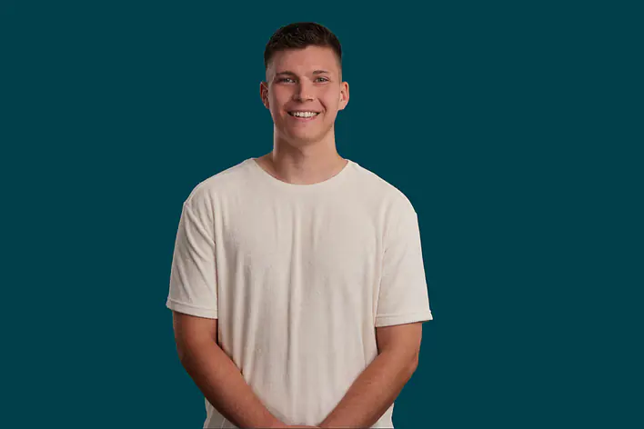 Student vor petrolfarbenem Hintergrund