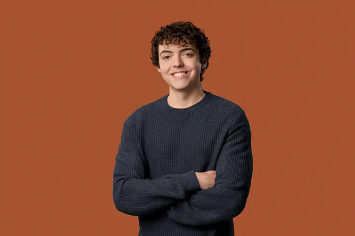 Student vor orangefarbenem Hintergrund